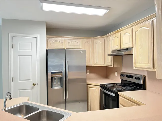 a kitchen with stainless steel appliances granite countertop a sink stove and refrigerator