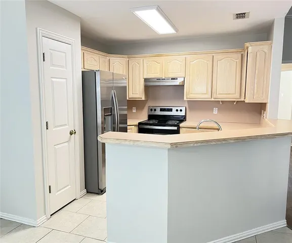 a kitchen with stainless steel appliances a refrigerator sink and cabinets