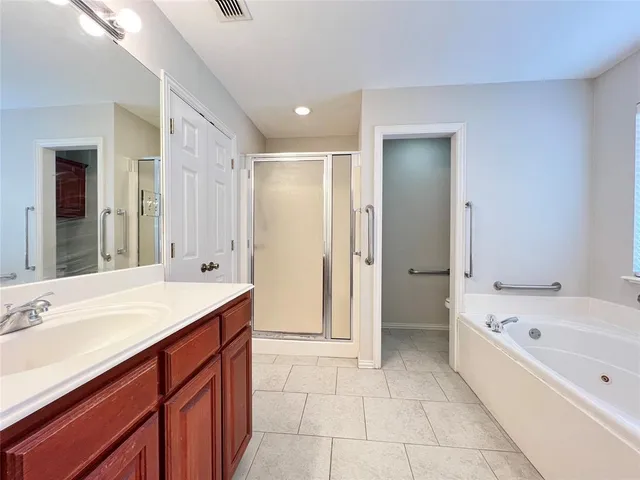 a bathroom with a tub sink shower and mirror