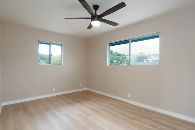 an empty room with a window and a fan