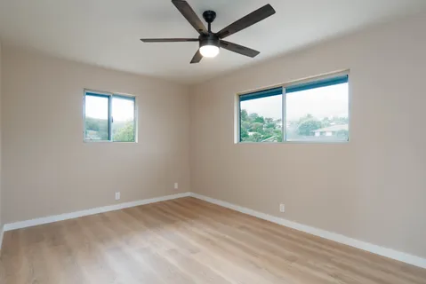 an empty room with a window and a fan