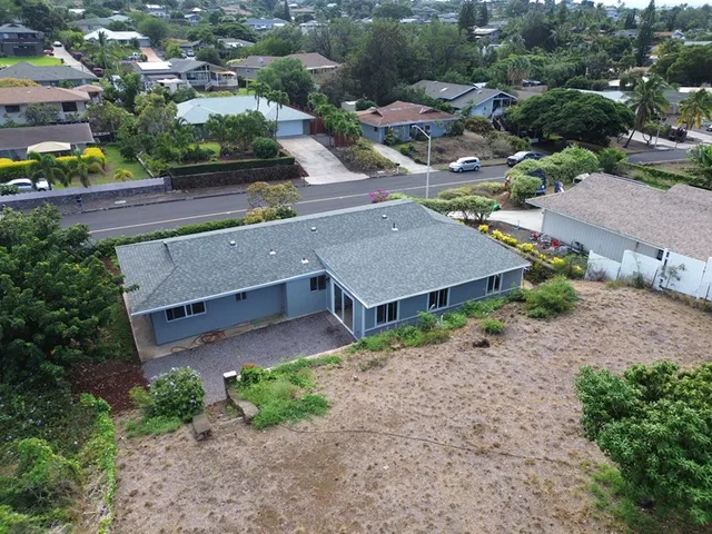 an aerial view of a house with a yard and greenery