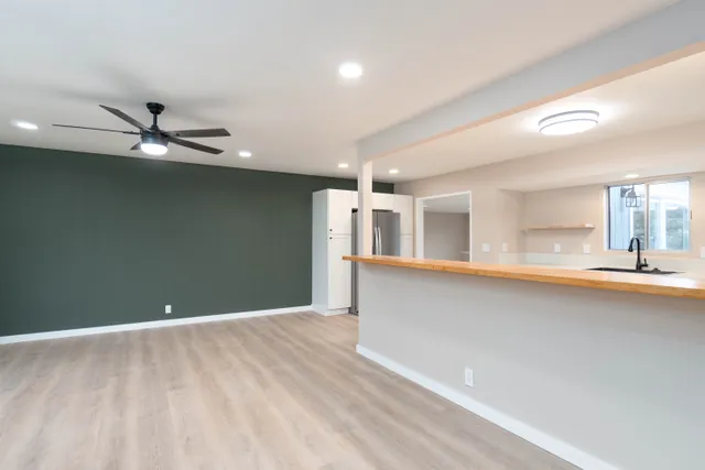 a view of a livingroom with a ceiling fan and wooden floor