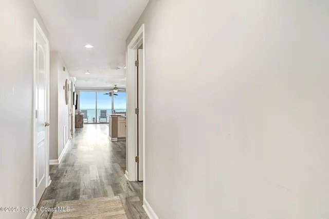 a view of a hallway with wooden floor