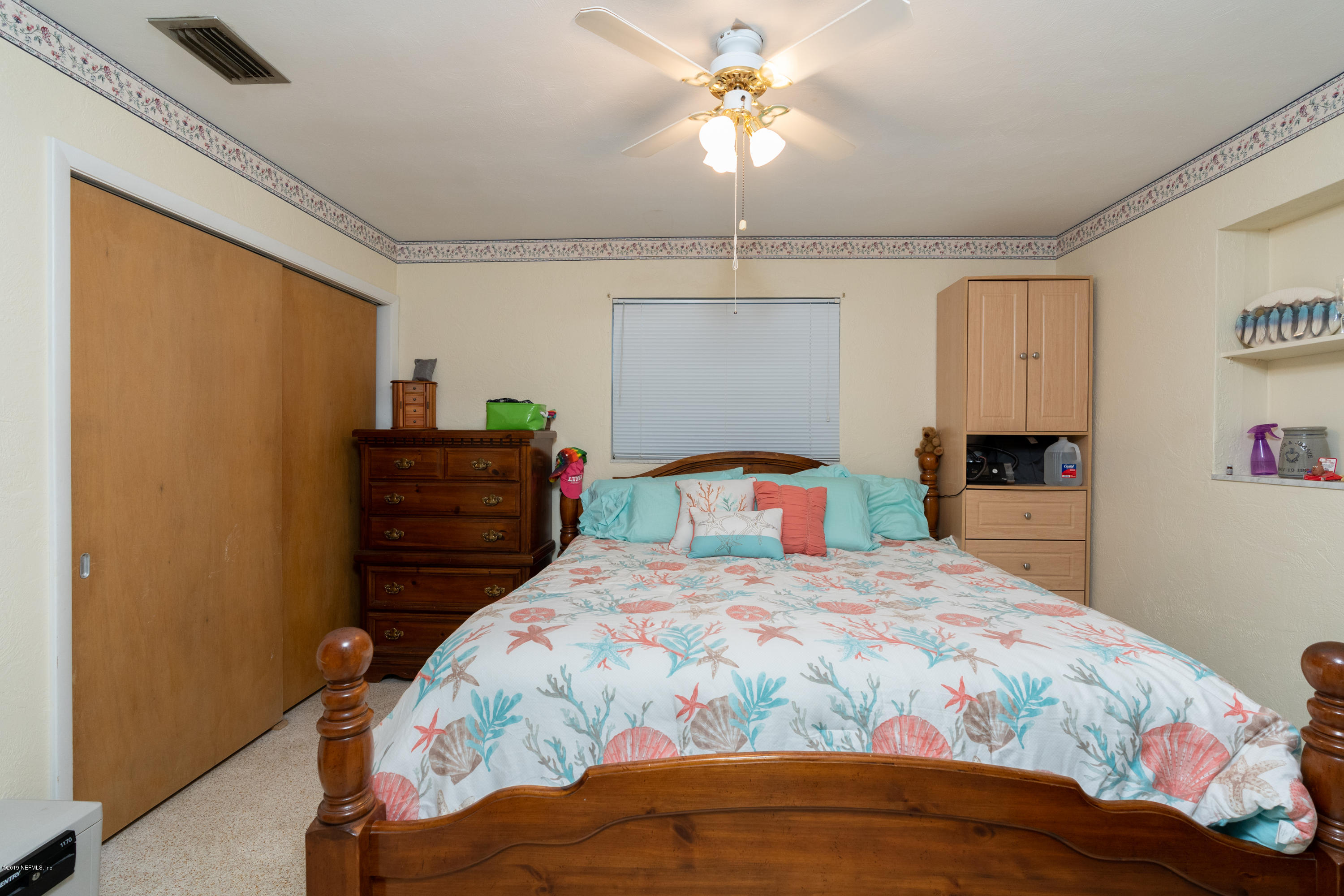 34 Ocean Drive St. Augustine, FL 32080 - Photo 26 of 36 a bedroom with a bed and a chandelier