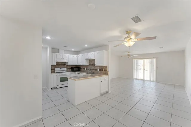 a kitchen with white cabinets and sink