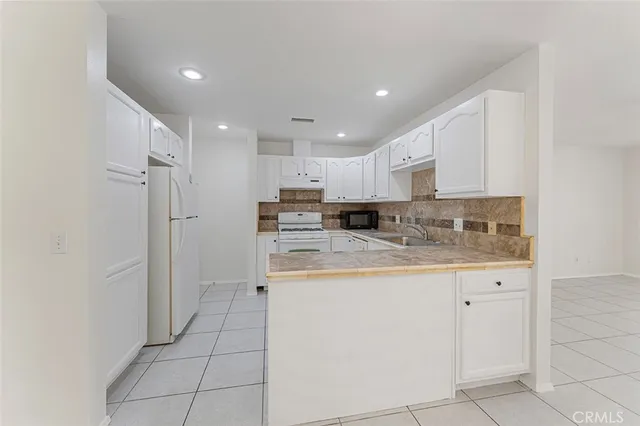 a kitchen with kitchen island granite countertop white cabinets and stainless steel appliances