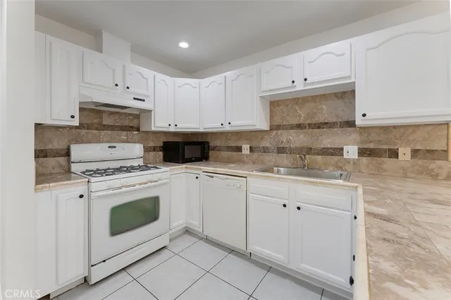 a kitchen with cabinets appliances a sink and a counter top