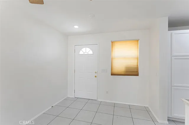 a view of an empty room with closet and a window