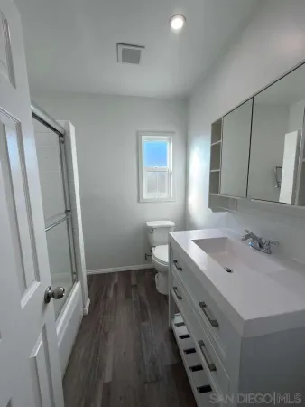 a bathroom with a sink a toilet and a mirror