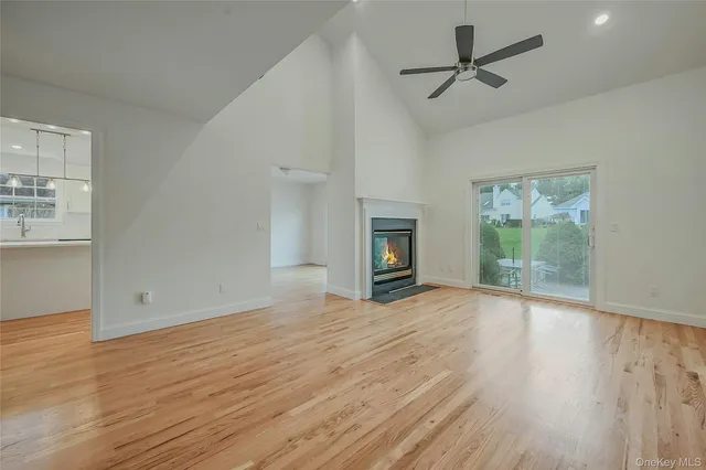 a view of empty room with wooden floor and fireplace