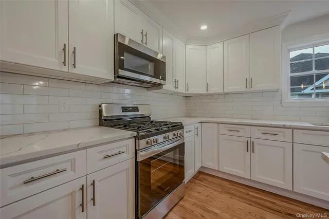 a kitchen with white cabinets stainless steel appliances and sink
