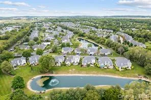 an aerial view of residential houses with outdoor space and trees