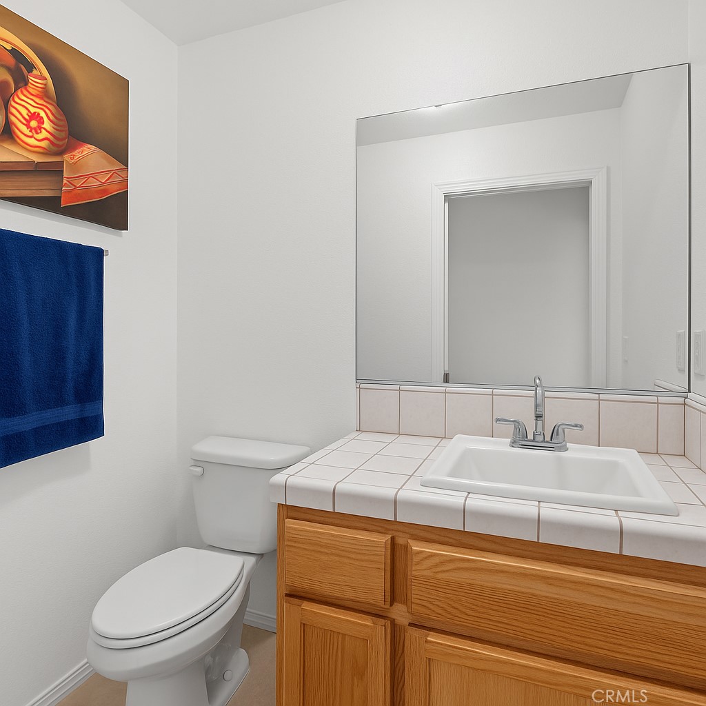 13776 Natoma Road Apple Valley, CA 92307 - Photo 22 of 40 a bathroom with a toilet sink and mirror
