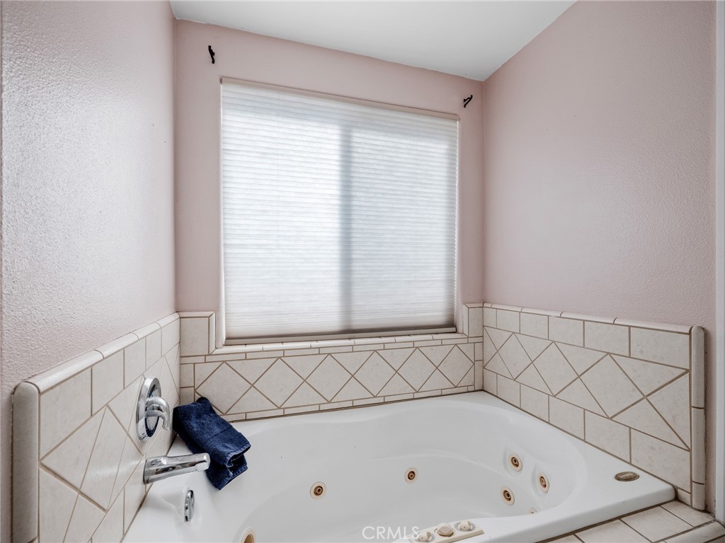 13776 Natoma Road Apple Valley, CA 92307 - Photo 27 of 40 a bathroom with a bathtub and next to a window