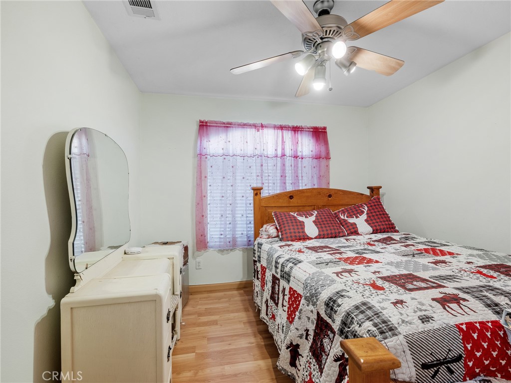 13776 Natoma Road Apple Valley, CA 92307 - Photo 28 of 40 a bedroom with a bed and a chandelier