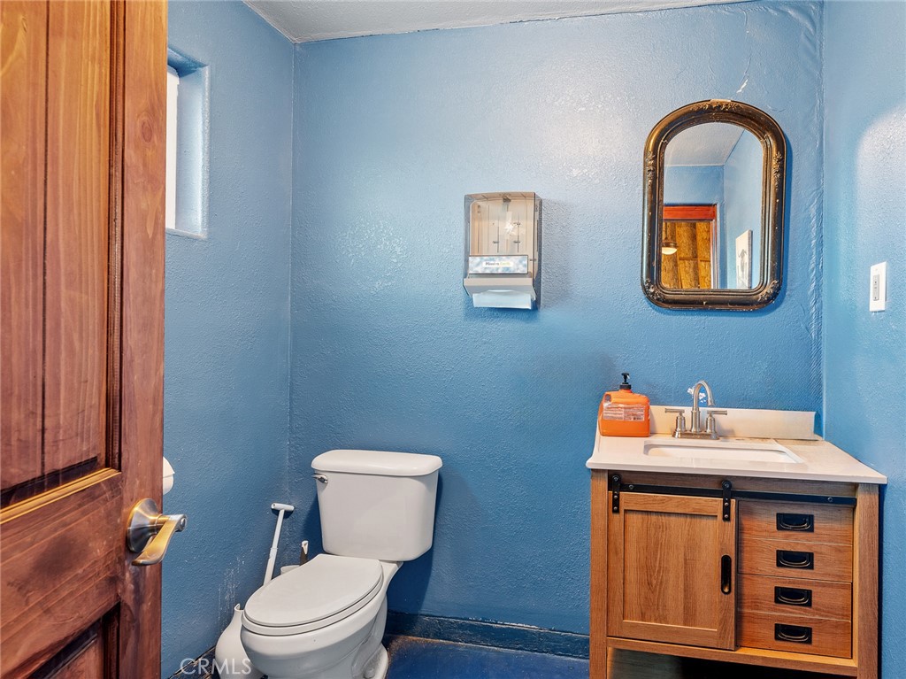 13776 Natoma Road Apple Valley, CA 92307 - Photo 35 of 40 a bathroom with a toilet a sink and a mirror