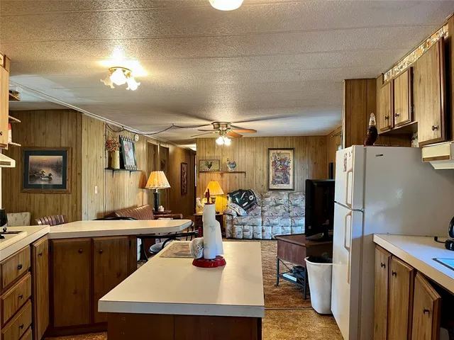 a kitchen with sink refrigerator and cabinets