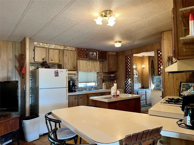 a kitchen with a table chairs refrigerator and microwave