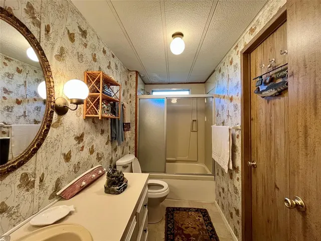 a bathroom with a tub shower sink and mirror