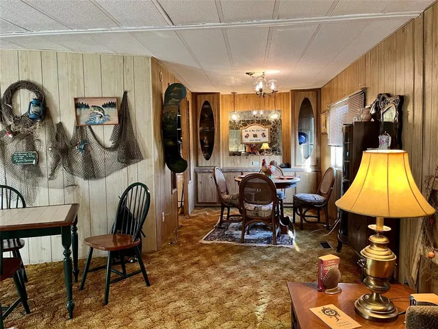 a living room with furniture a chandelier and a floor to ceiling window
