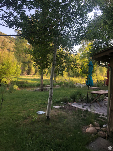 13581 13581st Huntsville, UT 84317 - Photo 8 of 11 Expansive green lawn with mature trees and a wooden deck