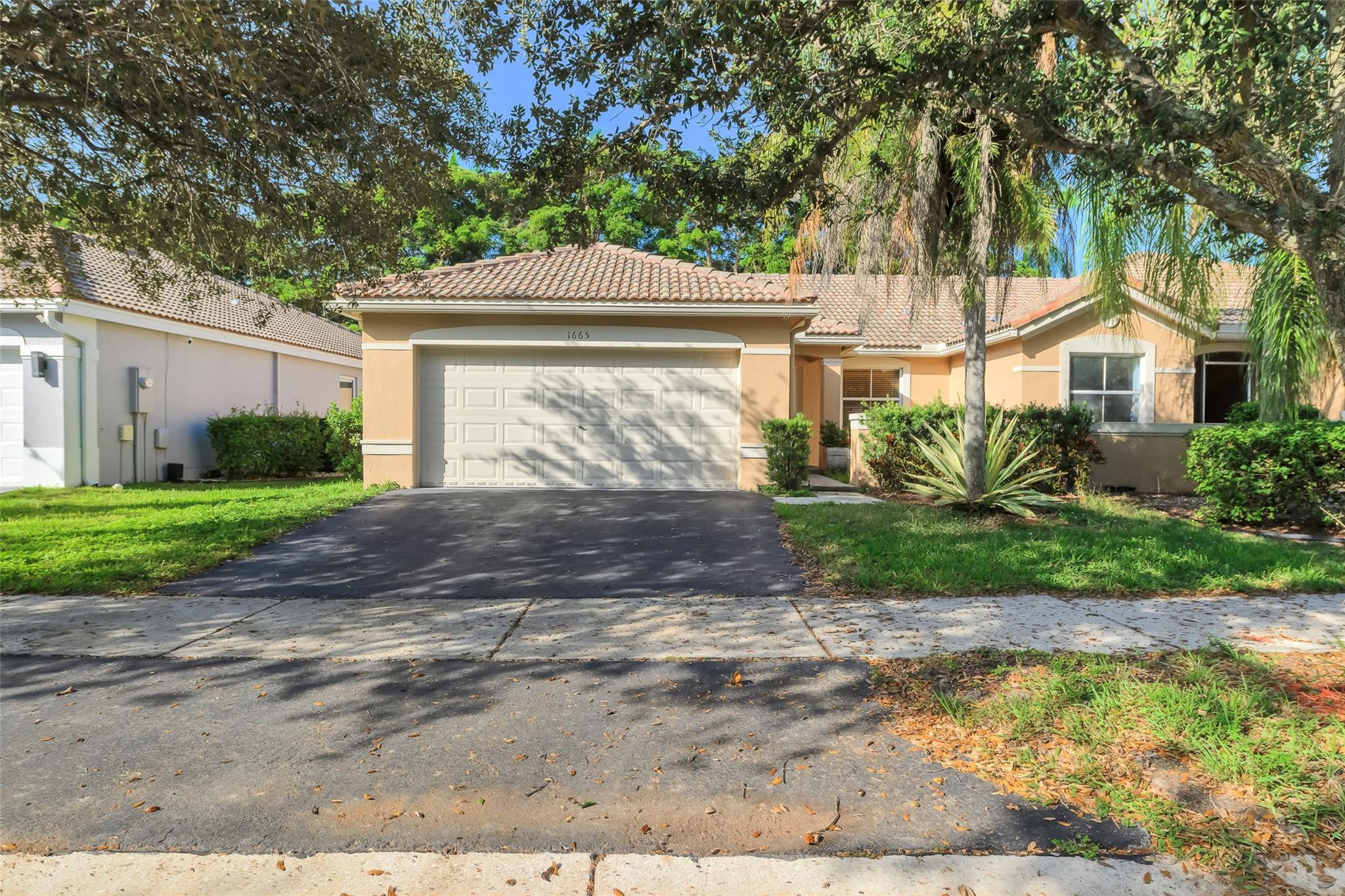 1665 Zenith Way Weston, FL 33327 - Photo 1 of 22 a front view of a house with a yard and garage