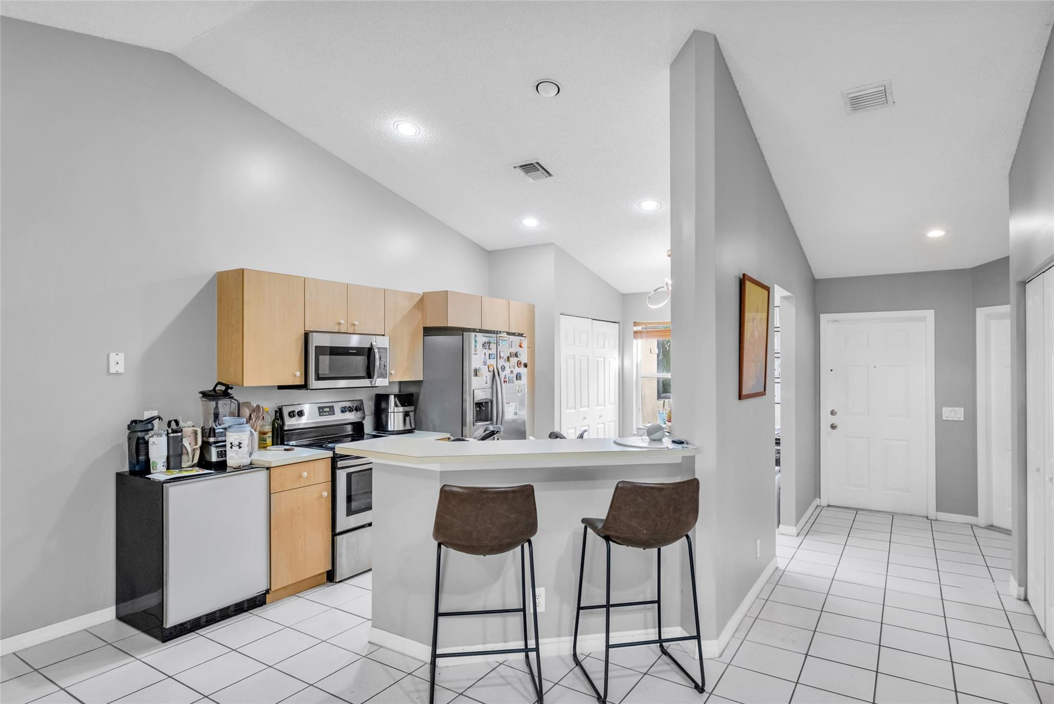 1665 Zenith Way Weston, FL 33327 - Photo 11 of 22 a kitchen with stainless steel appliances a sink a stove a refrigerator cabinets and a dining table