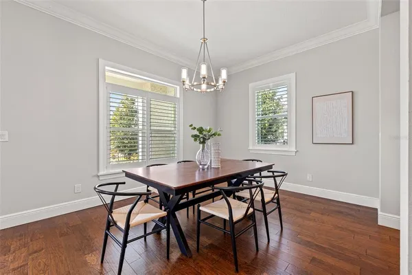 a dining room with furniture a chandelier and wooden floor