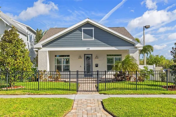 a front view of a house with a garden and plants