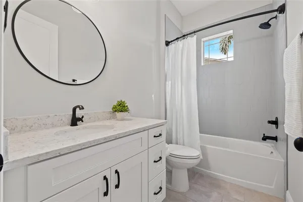 a bathroom with a granite countertop sink a toilet and a mirror