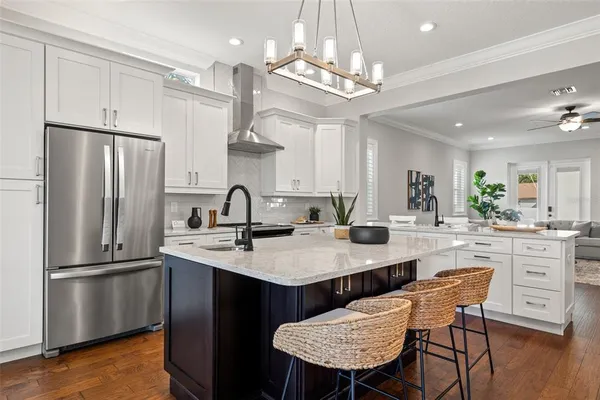 a kitchen with stainless steel appliances granite countertop a dining table chairs stove a refrigerator and kitchen view