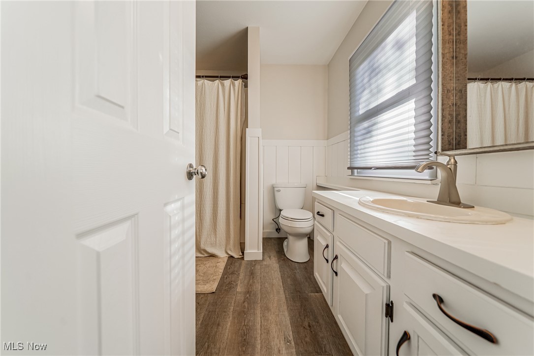 595 Moorfield Road Fairlawn, OH 44313 - Photo 27 of 50 Second floor bathroom featuring dark wood-type flooring, vanity, a wainscoted wall, and a shower with curtain