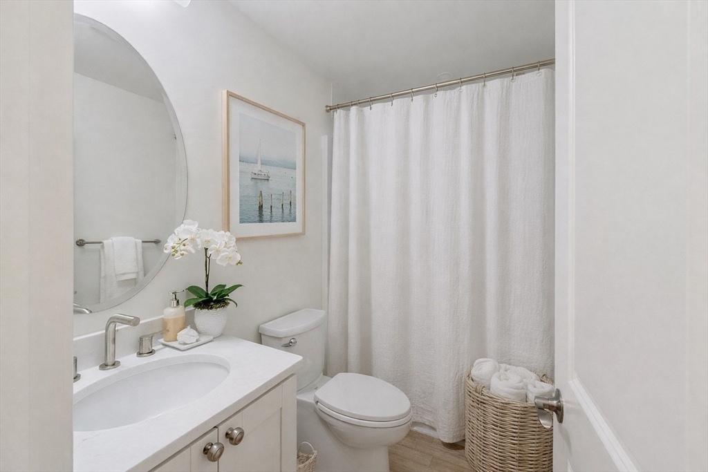206 West Main Street, Unit 9 Georgetown, MA 01833 - Photo 19 of 25 a bathroom with a sink a toilet and shower curtain