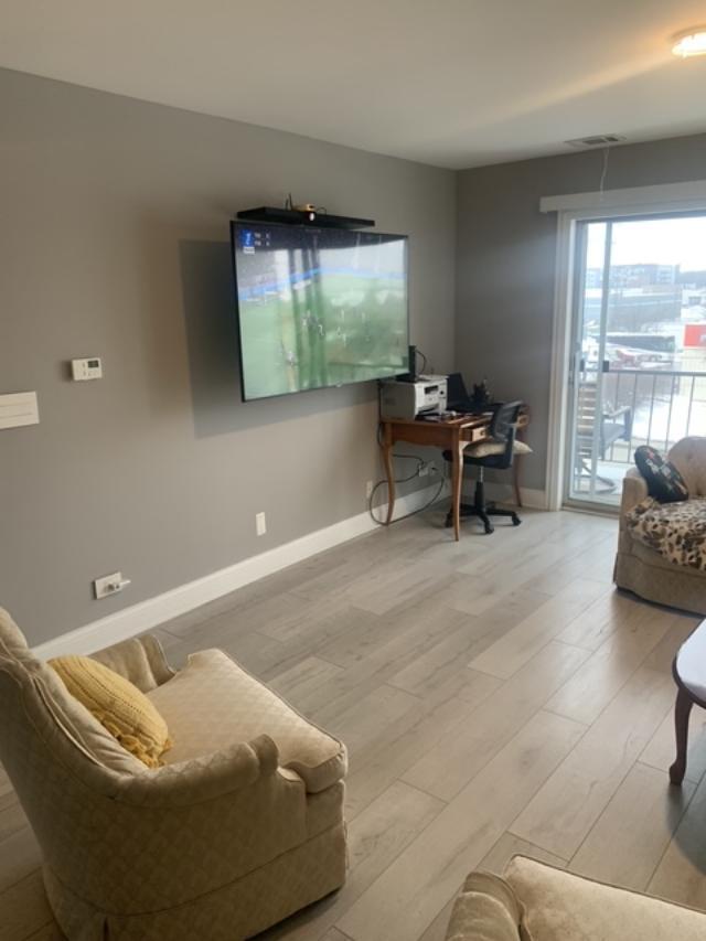 8620 Waukegan Road, Unit 308 Morton Grove, IL 60053 - Photo 5 of 10 a living room with furniture and a flat screen tv