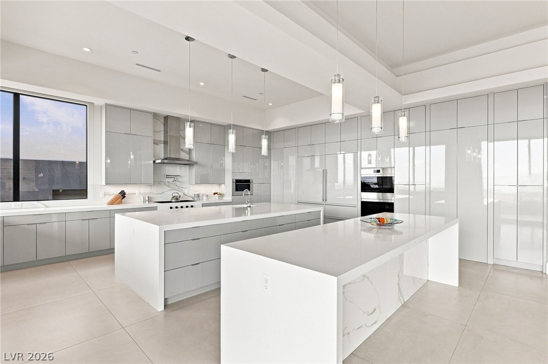 677 Overlook Rim Drive Henderson, NV 89012 - Photo 21 of 97 Double islands anchored by stone countertops elevate this contemporary culinary space.