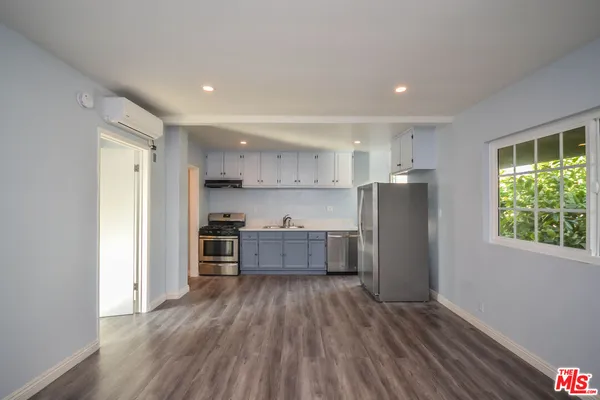 a kitchen with stainless steel appliances a refrigerator and a stove top oven