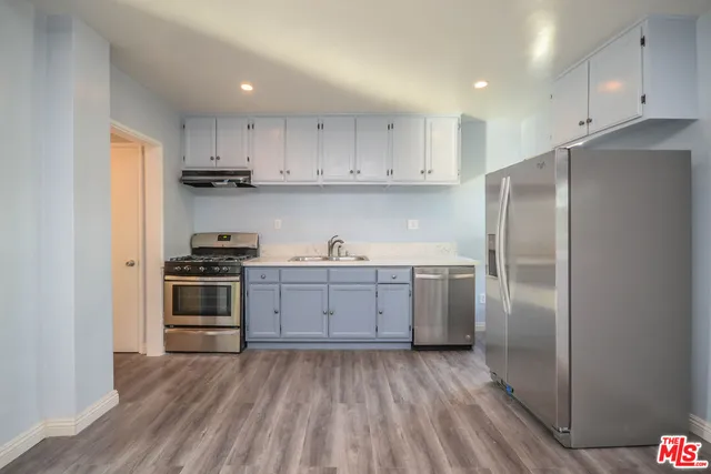a kitchen with a refrigerator sink and cabinets