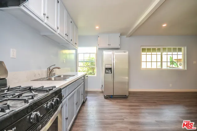 a kitchen with stainless steel appliances granite countertop a stove a sink dishwasher a refrigerator and a stove