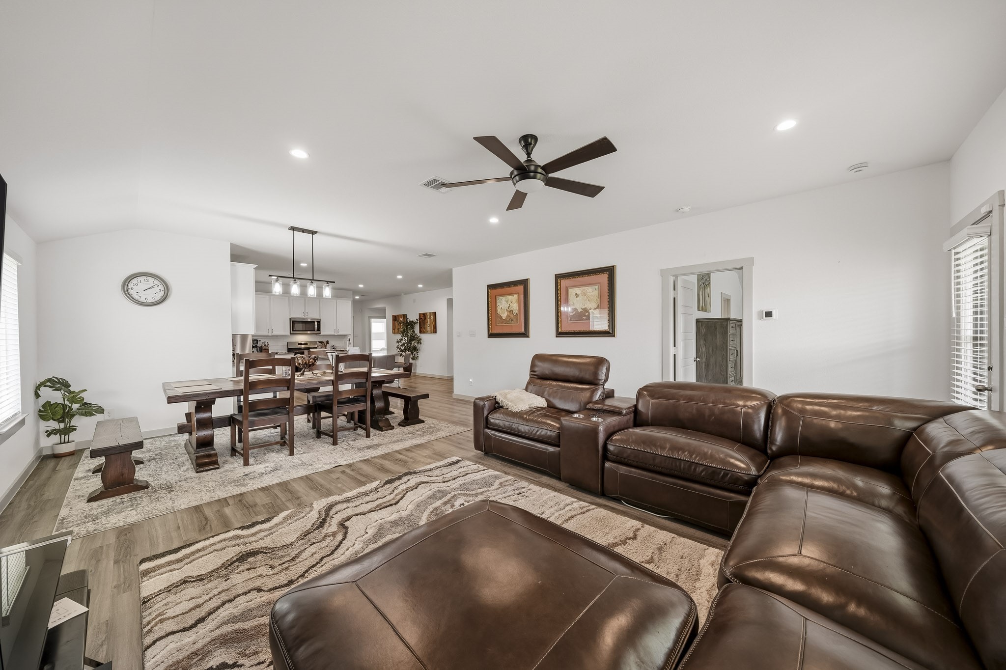 919 Tall Shire Court Rosharon, TX 77583 - Photo 3 of 19 This expansive main floor layout offers a warm, inviting atmosphere with room for the whole family to gather. The airy living room features high ceilings and plush sectional seating, transitioning naturally into a dedicated dining space.
