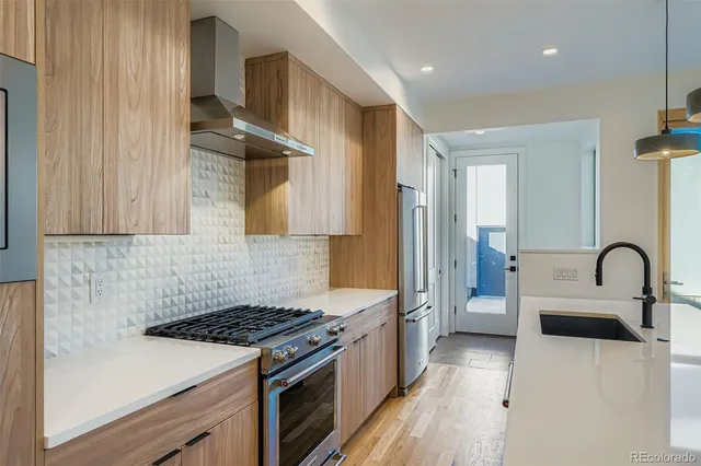 a kitchen with granite countertop a sink stainless steel appliances and cabinets