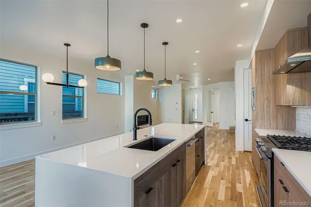 a kitchen with kitchen island a sink a counter and a stove