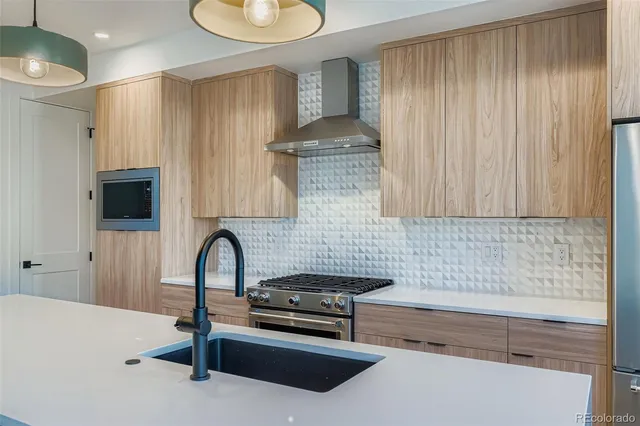 a kitchen with stainless steel appliances a stove a sink and a microwave