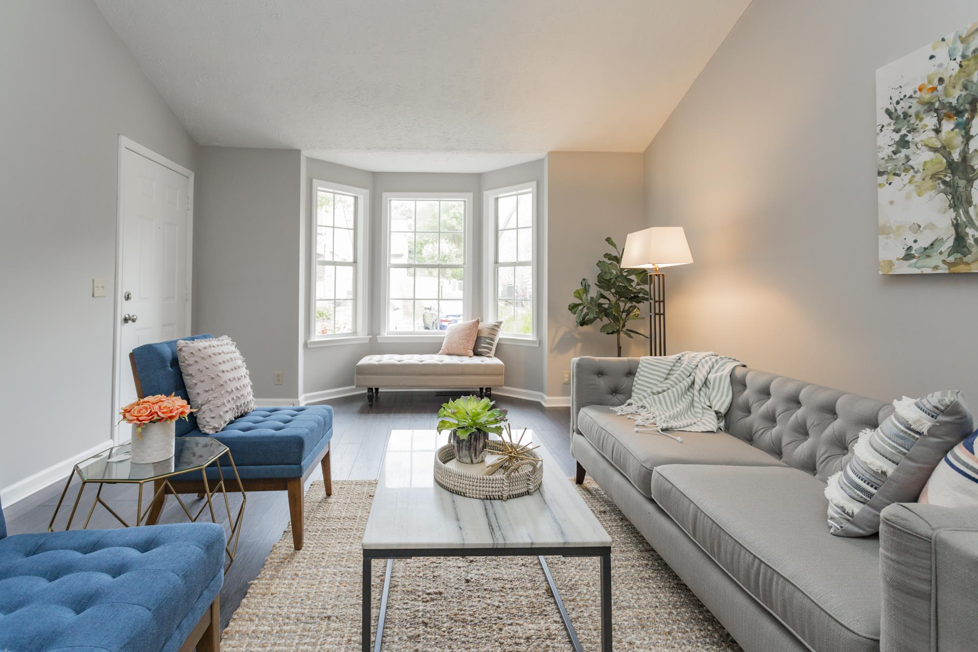 Opposite the fireplace, the bay window provides abundant natural light.
