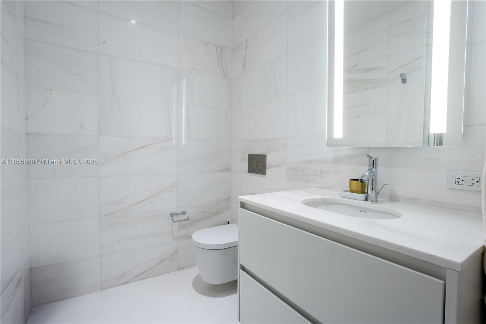 300 Biscayne Blvd Way, Unit 2203C Miami, FL 33131 - Photo 27 of 30 a bathroom with a sink a toilet and a mirror