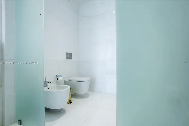 a white toilet sitting next to a white sink