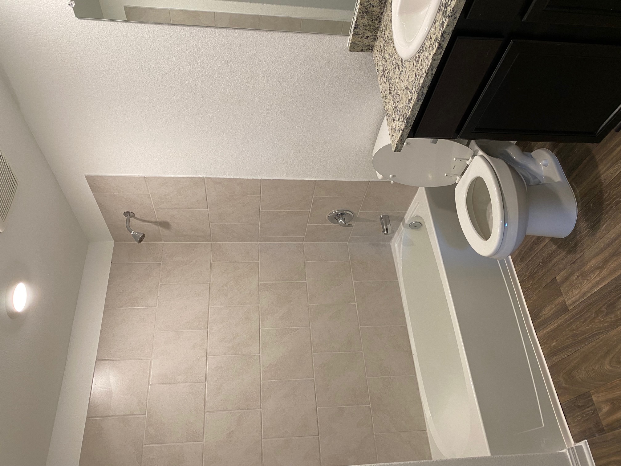 18308 Speculator Lane Elgin, TX 78621 - Photo 7 of 16 a bathroom with a granite countertop toilet a sink and bathtub