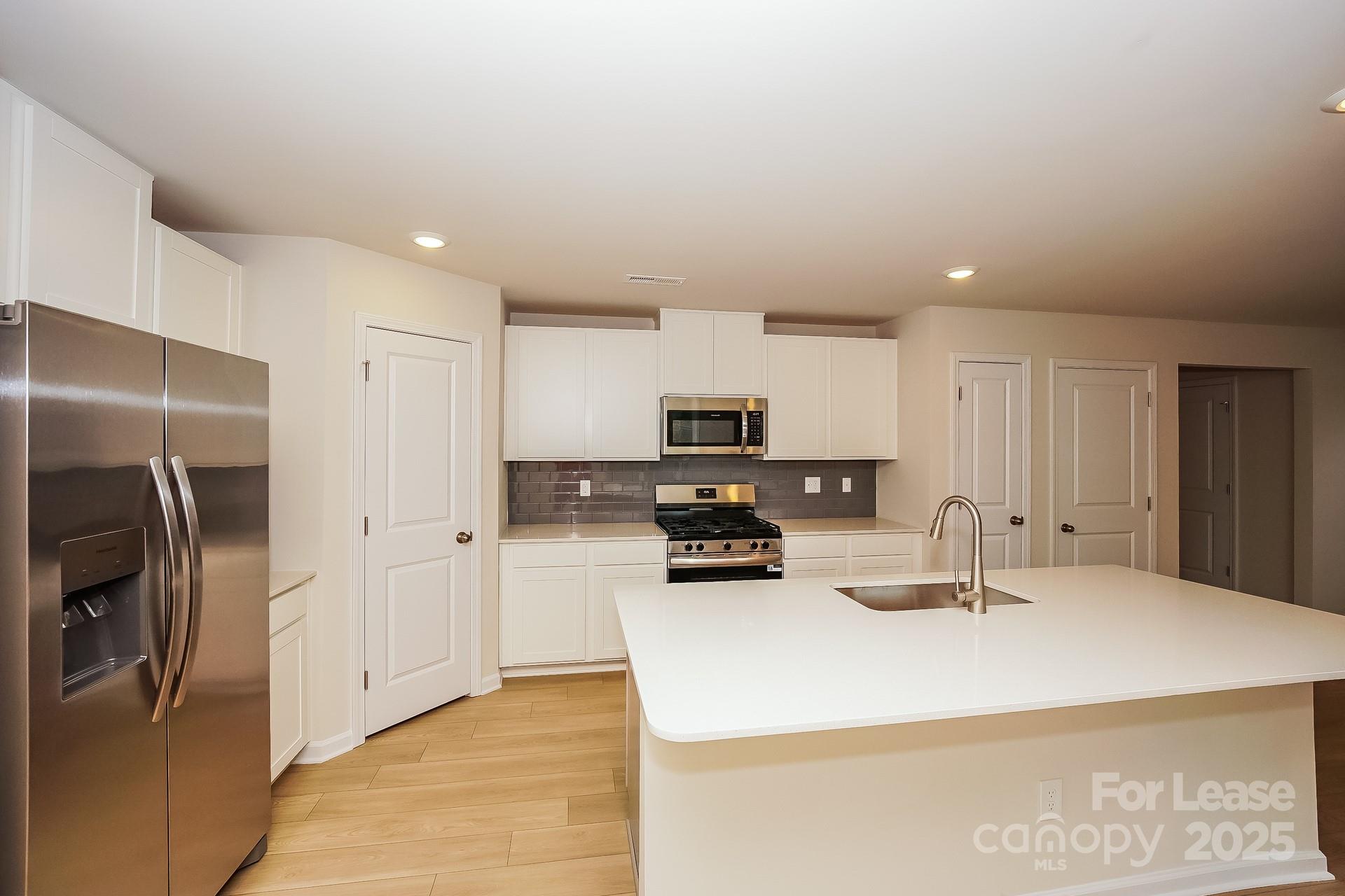 143 Arden Court Troutman, NC 28166 - Photo 11 of 18 a kitchen with stainless steel appliances a refrigerator sink and stove