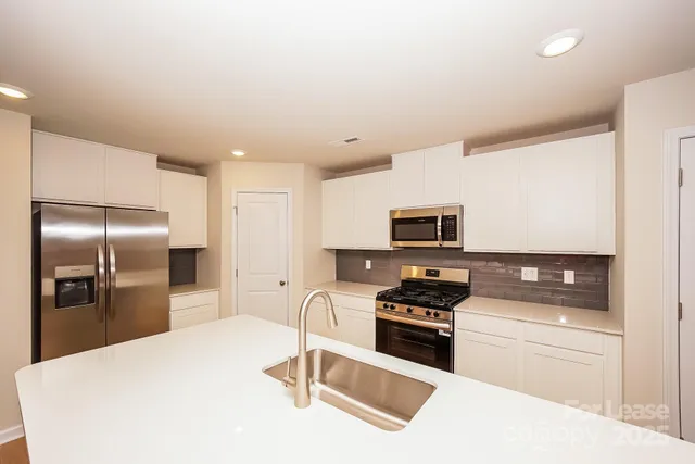 a kitchen with stainless steel appliances a refrigerator sink and stove