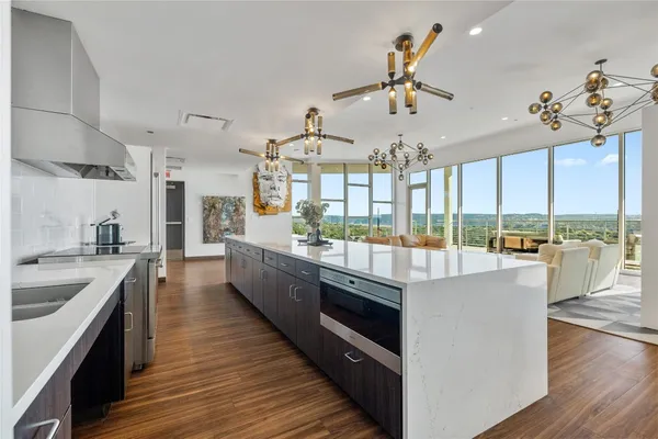 a large kitchen with lots of counter space wooden floor and stainless steel appliances
